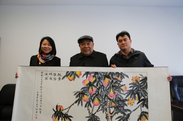 吴老向学院赠送他专为校庆而作的画《桃李芬芳硕果满园》